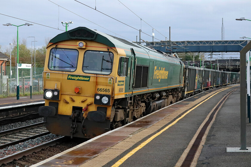 66565, 13.21 Willesden Up & Down Relief-Tunstead Sidings (6H50, 3E), Wolverton station 
 The characteristic rust stain down the front end emanating from beneath the windscreen seal, a common affliction of the Class 66s, 665645 speeds through Wolverton station leading the 6H50 13.21 Willesden to Tunstead empty stone wagons train. This, and the balancing loaded working are in association with HS2 and its work in West London. 
 Keywords: 66565 13.21 Willesden Up & Down Relief-Tunstead Sidings 6H50 Wolverton station