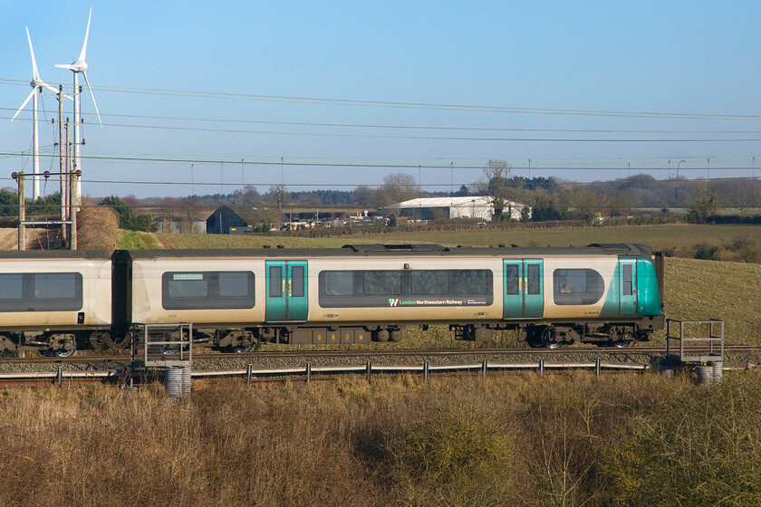 350239, LN 12.06 Birmingham New Street-London Euston (1Y18, 2E), Roade Hill 
 A broadside view of the 12.06 Birmingham New Street to Euston service as it passes just south of Roade worked by 350239 (leading). This will be one of the units that will be heading back to their owner in the not-too-distant future as West Midlands Trains belatedly introduce the Class 730s to traffic. 
 Keywords: 350239 12.06 Birmingham New Street-London Euston 1Y18 Roade Hill London Northwestern Desiro