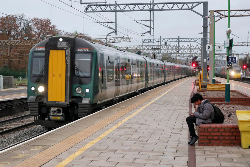 350124, LN 15.39 London Euston-Miton Keynes Central (2K41, 4L) & 390119, VT 15.43 London Euston-Liverpool LS (1F28, 2L), Watford Junction station 
 Being 16.00 and mid-November the light is rapidly failing making photography a challenge! However, modern camera technology means reasonable and presentable photographs are possible as seen here. 350124 arrives at Watford Junction working the 15.39 Euston to Milton Keynes service. As it does so, 390119 'Progress' just puts in an appearance to the extreme right working Avanti's 15.43 Euston to Liverpool Lime Street. 
 Keywords: 350124 15.39 London Euston-Milton Keynes Central 2K41 390119 15.43 London Euston-Liverpool Lime Street 1F28 Watford Junction station Progress