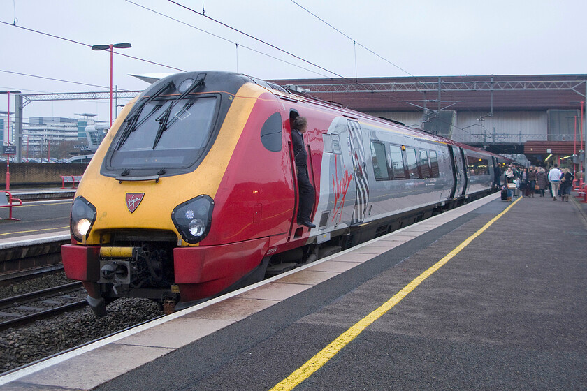 221114, VT 05.50 Glasgow Central-London Euston (9M48), Birmingham International station 
 The driver of 221114 takes some air as his charge pauses at Birmingham International. His train the 9G48 05.50 Glasgow Central to Euston has just arrived worked by 222114. The time will (and not before time) when we should see an end to these dreadful diesels running under the wires on services such as this. 
 Keywords: 221114 05.50 Glasgow Central-London Euston 9M48 Birmingham International station