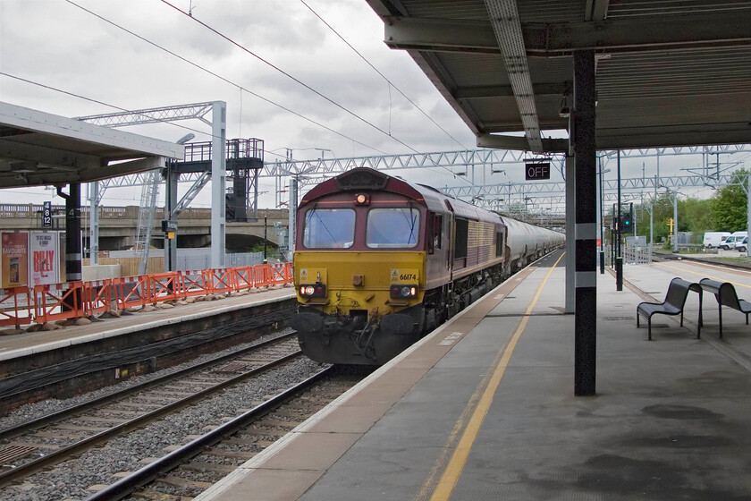 66174, unidentified down freight, Bletchley station 
 A rather head-on shot of 66174 as it passes through Rugby station at speed heading north. Despite trawling the working timetable I cannot identify this working unless anybody can advise please. 
 Keywords: 66174 down freight Bletchley station