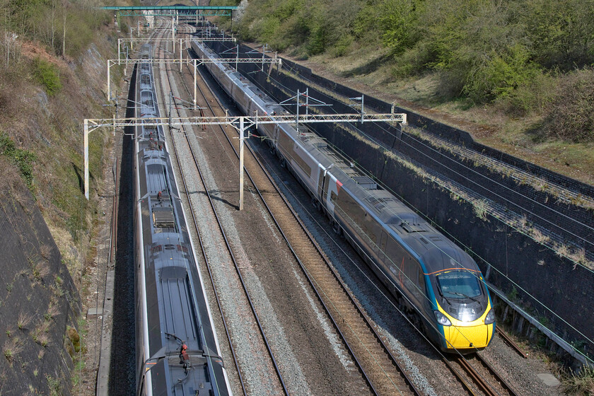 390114, VT 09.51 London Euston-Wolverhampton (9G04, 5L) & 390128, VT 09.00 Preston-London Euston (1A04, 4L), Roade cutting 
 It is quite common for the Weedon route avoiding Northampton to be closed on Saturday night and into Sunday morning with it reopening around 11.00. The first down train to use the route and the penultimate diverted up train are seen passing through Roade cutting. To the left 390114 'City of Manchester' works the 09.51 Euston to Manchester whilst the eponymous 390114 'City of Preston' works the 09.00 Preston to Euston. 
 Keywords: 390114 09.51 London Euston-Wolverhampton 9G04 390128 09.00 Preston-London Euston 1A04 Roade cutting Avanti Coast Pendolino City of Manchester City of Preston