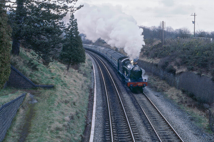 4930, outward leg of The Welsh Marches Express, 10.15 Crewe-Newport, Llanvihangel Summit SO314199 
 With an engine change taking place at Hereford we had plenty of time to get well south to record The Welsh Marches Express for a third time on its journey from Crewe to Newport. In this scene at Llanvihangel Summit 4930 'Hagley Hall' is about to crest and then take the long descent through Abergavenny and to Newport. Notice the brick abutment to the left that was once the pedestrian access to Llanvihangel stations up platform. To the right was a short siding with the down platform on the other side of the bridge on which I am standing. Looking on Google Earth today reveals that the scene, both north and south, is exactly the same with the pathway now permitting access for Network Rail staff and their contractors. 
 Keywords: 4930 The Welsh Marches Express 10.15 Crewe-Newport Llanvihangel Summit SO314199 Hagley Hall