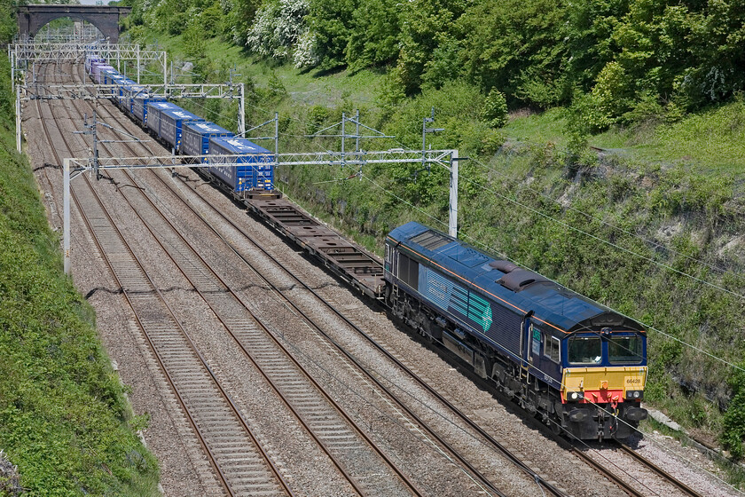 66428, 12.03 DIRFT-Tilbury Freightliner Terminal (4L48), Hyde Road bridge 
 The up 'Tesco Express' 4L48 12.03 Daventry to Tilbury service passes through Roade cutting lead by DRS' 66428. Running seven days per week the train is part of Stobart Rail's logistic portfolio with their branding now confined to the roof of the boxes where it used to be on the flanks as well with these now carrying the Les Co2 Rail moniker. 
 Keywords: 66428 12.03 DIRFT-Tilbury Freightliner Terminal 4L48 Hyde Road bridge DRS Tesco Express