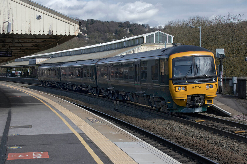 166204, GW 13.23 Portsmouth Harbour-Cardiff Central (1F20, 2L), Bath Spa station 
 The only named Networker Turbo 166204 'Norman Topsom MBE' leaves Bath Spa station working the 13.23 Portsmouth Harbour to Cardiff Central service. Back in my early spotting years, I spent many hours here at Bath back in the 1970s taking photographs, I stood in a very similar position back in November 1980 and took the following photograph, see.... https://www.ontheupfast.com/p/21936chg/29805505604/class-43-hst-down-working-bath-spa This unit was named in honour of the former Twyford station master Norman Topsom MBE who finally retired from the railway in November 2015. 
 Keywords: 166204 13.23 Portsmouth Harbour-Cardiff Central 1F20 Bath Spa station Great Western Railway Norman Topsom MBE Networker Turbo