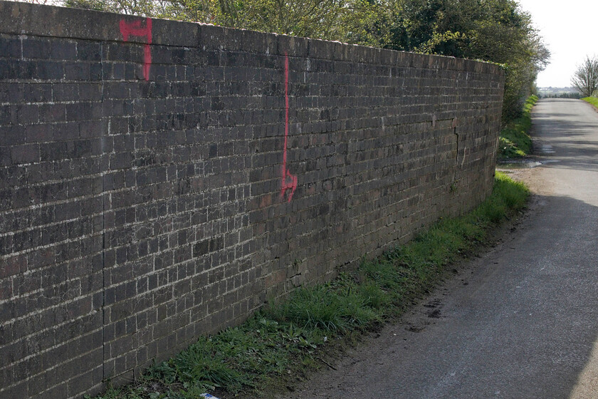 Structural movement, Bridge 204, Ashton Road 
 This photograph does not really show the angle that the parapet wall of Bridge 204 is at directly above the down fast line of the WCML just south of Roade. It would only need a strike from a passing vehicle and I think that it would be down on the track below; quite a worry. The eastern end of the bridge was repaired fairly recently but another six-week road closure is now required to complete this repair that will involve the complete removal of this parapet wall and its rebuilding in the vertical! All this will be taking place directly above the fully operational up and down fast running lines! 
 Keywords: Structural movement Bridge 204, Ashton Road