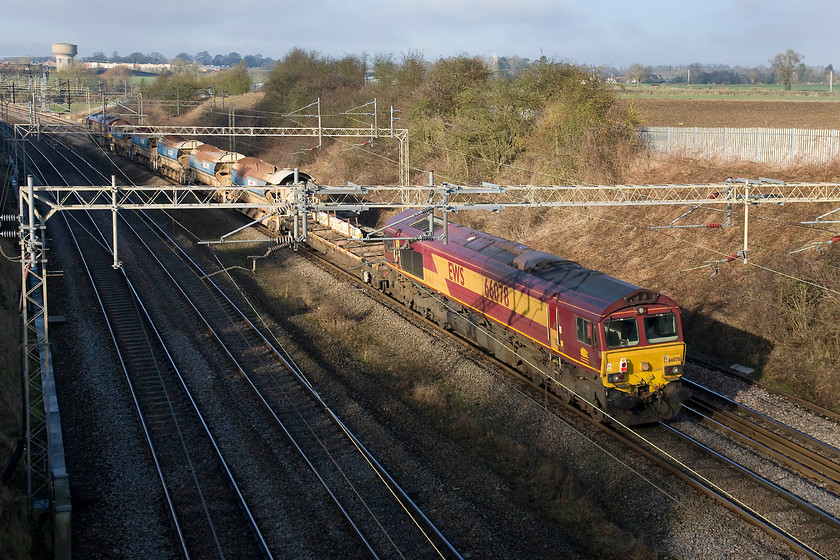 66078, 12.02 Willesden West London Junction-Crewe Basford Hall, Victoria bridge 
 I am not a fan of going-away shots but when it's a short train of this type, it really makes very little difference. Also, in such lovely winter light this scene looks so good it just had to be taken! 66078 is trailing along at the rear of the 12.02 Willesden West London Junction to Crewe Basford Hall engineering train with 66024 doing the work up at the front. The combo is seen passing Victoria bridge, a spot very close to my home, that is actually in this view across the fields in the distance, near to Roade in Northamptonshire. 
 Keywords: 66078 12.02 Willesden West London Junction-Crewe Basford Hall Victoria bridge