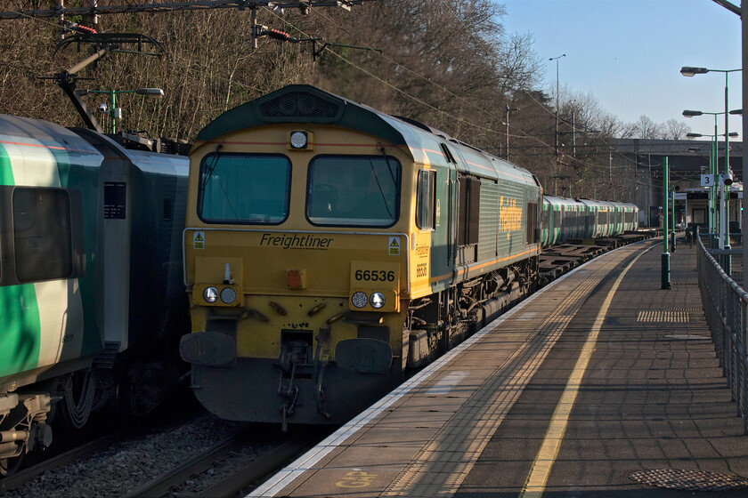 66536, 11.13 Felixstowe North-Trafford Park (4M87, 14E), Kings Langley station 
 As an up Desiro service pauses at Kings Langley station the 4M87 Felixstowe North to Trafford Park Freightliner heads north with 66536 leading. Whilst the front of the 'liner is devoid of boxes there were plenty towards the rear of the train. However, it is always a cause for concern when freight trains travel only half-loaded. The large concrete bridge in the background carries the M25 orbital motorway over the railway and then on a viaduct over the valley of the River Gade just near to Junction 20. 
 Keywords: 66536 11.13 Felixstowe North-Trafford Park 4M87 Kings Langley station Freightliner