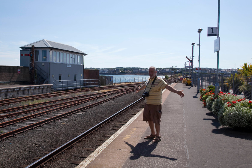 Andy, Stranraer station 
 Andy on the platform of Stranraer station. Despite the general rundown nature of the station surroundings, the staff make an effort to keep it as attractive as possible with flower boxes and an a general air of cleanliness. As can be seen, the starter signal behind Andy is off. The box is switched out so all trains are controlled by the next box along the line at Dunragit. 
 Keywords: Andy Stranraer station