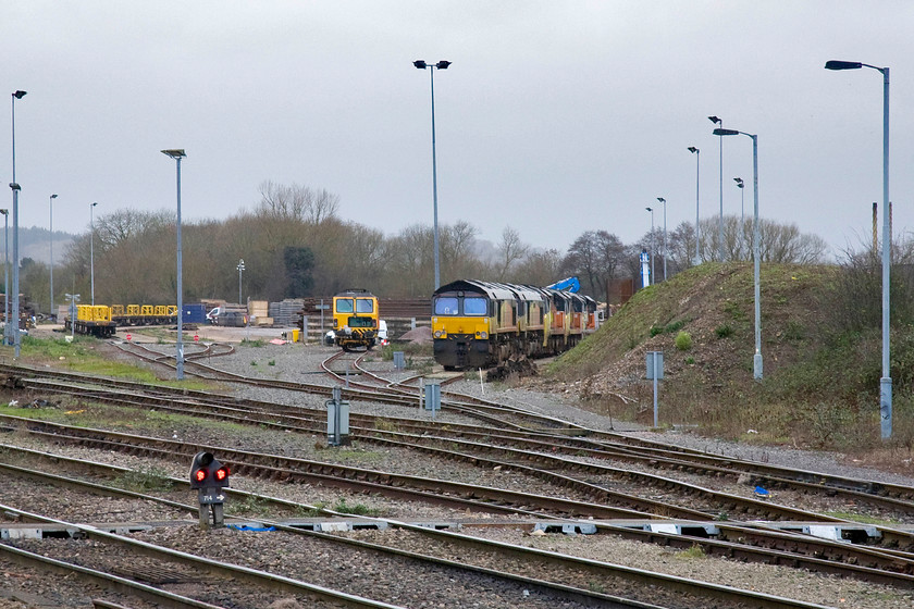 Class 66s & class 70s, stabled, Westbury yard 
 Westbury yard remains a very important hub for freight linked to the nearby Mendip quarries and this has been the case for many years back to when I was young spotter on the station back in the 1970s, see.... https://www.ontheupfast.com/p/21936chg/C296307204/x4-westbury-27-03-76 Today the depot has gone that used to undertake basic maintenance of Westerns and Class 47s to be replaced by straightforward stabling sidings. On this dismal December day, there are two Colas Class 66s and three Class 70s. 
 Keywords: Class 66s class 70s stabled Westbury yard