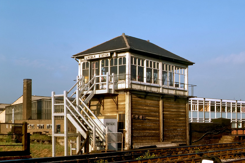 Lincoln Station signal box (Mid, date not known) 
 The rather tired-looking Lincoln Station signal box is seen in the evening sunshine. This is a Midland box but its date of construction is a bit of a mystery unless anybody can furnish me with some information on this? Graham and I must have wandered off the end of the platform to take this photograph in full view of the signalmen unless we asked permission that I very much doubt! The box carries its original name, unlike that station that was renamed by British Railways to become Lincoln St. Marks from 1950. It was closed along with the station in May 1985 but stood derelict for a few years after that. In a nod to its heritage, the retail park that now occupies the site has a mock signal box that is the home to the management centre. 
 Keywords: Lincoln Station signal box