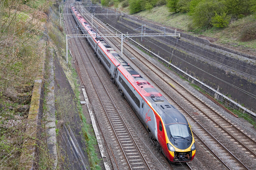 Class 390, VT 08.40 Glasgow Central-London Euston, Roade cutting 
 A Virgin Pendolino passes at line speed through Roade cutting working the 08.40 Glasgow Central to Euston train. Whatever this Pendolino is it is one of the re-formed eleven-car sets of the 3901XX sub-set. 
 Keywords: Class 390 08.40 Glasgow Central-London Euston, Roade cutting Virgin Pendolino