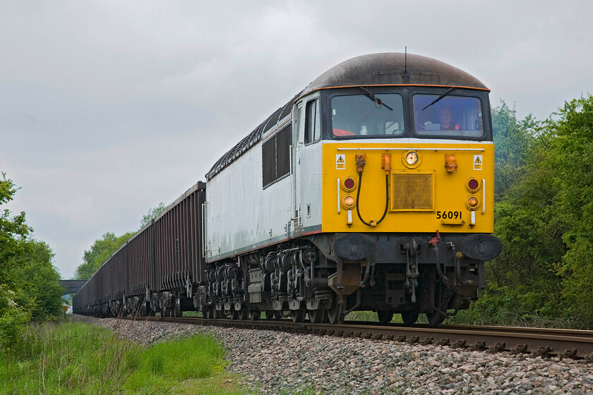 56091, 10.55 Calvert-Didcot PS (6Z91), Charndon SPSP676255 
 With the characteristic scream from 56091's turbocharger filling the countryside, it gets its long train of MBA 'super' box wagons away from Calvert as the 6Z91 to Didcot power station. The boxes are returning, having been emptied of their flyash into the Calvert landfill site, to be filled once again. I am standing legally at a footpath crossing near the village of Charndon. If all goes to plan, this train will only be in operation for another fortnight so I am glad that I made the effort to get out and see it. 
 Keywords: 56091 10.55 Calvert-Didcot Power station 6Z91 Charndon SPSP676255 DCR grid