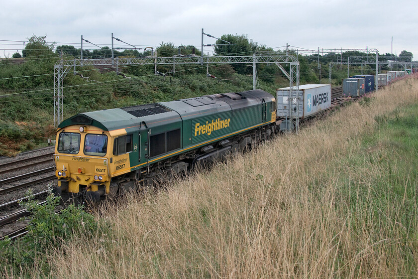 66517, 08.01 Felixstowe North-Crewe Basford Hall (4M81, 12E), Casey Lane SJ720519 
 One of the numerous local enthusiasts who had positioned themselves at Casey bridge just south of Basford Hall Junction told us that they manage to trim and strim the top of the embankment to the right in this image but that they cannot get to the lower slopes due to being in view of signalman in Basford Hall signal box just north of the bridge. By the end of the summer, the bank is fairly tall with various grasses that do spoil the view of trains on the down slow closest to it as seen here. 66517 approaches Basford Hall at an almost walking pace where it will terminate with the 4M81 08.01 from Felixstowe. 
 Keywords: 66517 08.01 Felixstowe North-Crewe Basford Hall 4M81 Casey Lane SJ720519 Freightliner