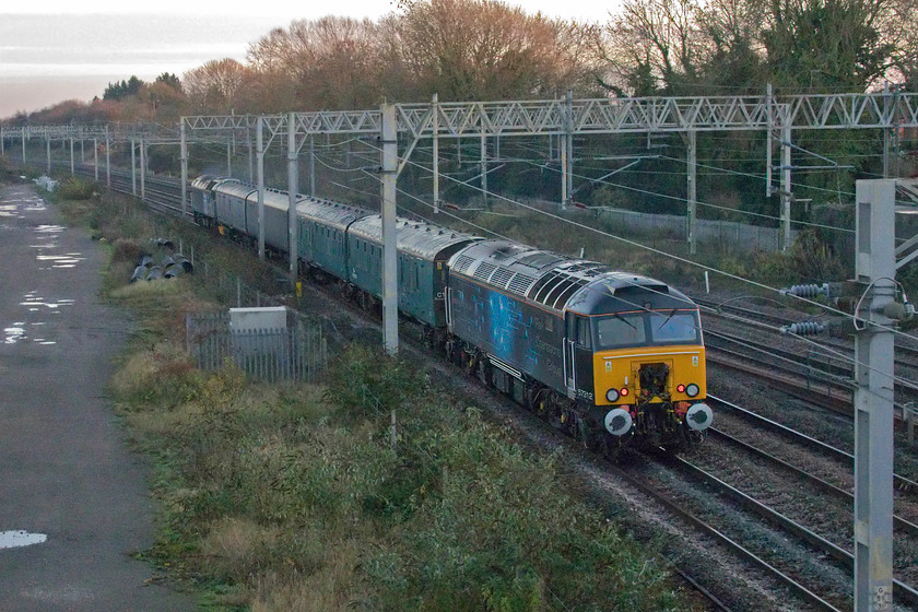 57312, 12.00 Derby RTC-Wolverton Centre Sidings (5H70, 13E), site of Roade station 
 A going-away photograph at Roade sees former Virgin Thunderbird 57312 dead-in-tow at the rear of the 12.00 Derby RTC to Wolverton Works 5H70 working running ten minutes early. It's difficult to make out but 57312 is painted in black with ROG blue vinyls over the top. At the front, 47813 'Jack Frost' is leading the train. The carriages were being moved to Wolverton to be used as barrier coaches the next day for the conveying of 442414 back to its home depot at Bournemouth by the two ROG locomotives. 
 Keywords: 57312 12.00 Derby RTC-Wolverton Centre Sidings 5H70 site of Roade station Jack Frost 47813