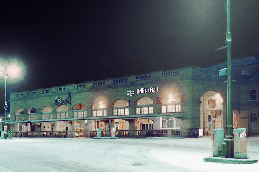 Frontage, York station 
 According to the clock, it is 07.05 but the total lack of light in the sky may suggest that this time is not correct. I would have thought that even at this time, only two weeks off the shortest day, that there would be some glow? Either way, this slide that was rescued from the rejects box, for obvious reasons, shows desolate station frontage at York with now attempt yet having been made to clear the roads of snow and ice. This frontage is unaltered today from this view taken some forty years previously, even the keep left boxes next to the ornate lamp post are still in the same position with just a bus shelter blocking this view across the appropriately named Station Road. 
 Keywords: Frontage York station