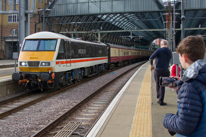 90001, outward leg of the London to Castle Howard, Durham, Beamish & Newcastle, 08.15 London King's Cross-Newcastle (1Z90, RT), London King's Cross station 
 Who said that railway enthusiasts are old geezers in anoraks? In the last year or so I have really begun to notice a newer breed of what we would have referred to as trainspotters. However, today there is no notebook and Combined volume in their pocket but rather a smart 'phone recording everything and then uploading it to the web. One of these young enthusiasts films (if a little off the horizontal I might point out!) 90001 'Royal Scot' as it departs from King's Cross leading the London to Castle Howard, Durham, Beamish & Newcastle charter. All went well on the day with timings maintained and 60009 'Sir Nigel Gresley' arriving back in London on time late the same evening. 
 Keywords: 90001 London to Castle Howard, Durham, Beamish & Newcastle 08.15 London King's Cross-Newcastle 1Z90 London King's Cross station Royal Scot