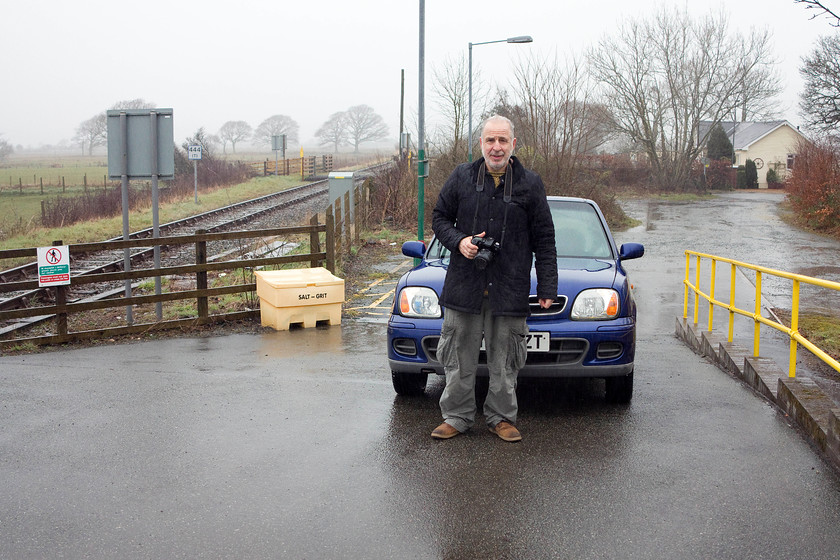 Andy & KY52ZFT, platform ramp, Talsarnau station 
 With the Micra virtually on the platform at Talsarnau station Andy stands in front in the rain! The occupier of the old station house was not keen on how far we had driven up the ramp reminding us that there was a small car park for our use. 
 Keywords: Andy KY52ZFT platform ramp Talsarnau station