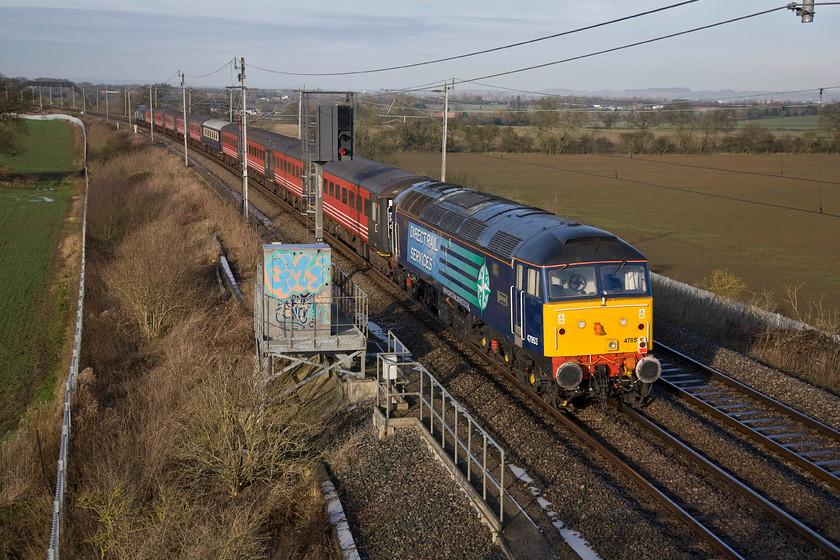 47853 & 47810, 09.40 Acton Reception Sidings-Crewe HS, Milton crossing 
 Dead in tow on the rear of the 09.40 Acton reception sidings to Crewe ESC move is 47853 'Rail Express'. Whilst most of the stock is in Virgin's colours but minus branding there is one Mk. II open first in the short-lived FM Rail Pullman livery. The train is seen on the down fast at Milton Crossing just north of Roade diverted away from the more normal Northampton route due to engineering works. 
 Keywords: 47853 47810 09.40 Acton Reception Sidings-Crewe HS Milton crossing Rail Express DRS Direct Rail Services