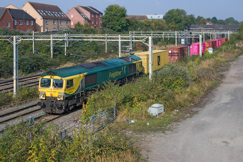 66414, 05.54 Trafford Park-London Gateway (4L44, RT), site of Roade station 
 The 4L44 05.54 Trafford Park to London Gateway Freightliner emerges from Roade cutting into some warm September sunshine lead by 66414. 
 Keywords: 66414 05.54 Trafford Park-London Gateway 4L44 site of Roade station