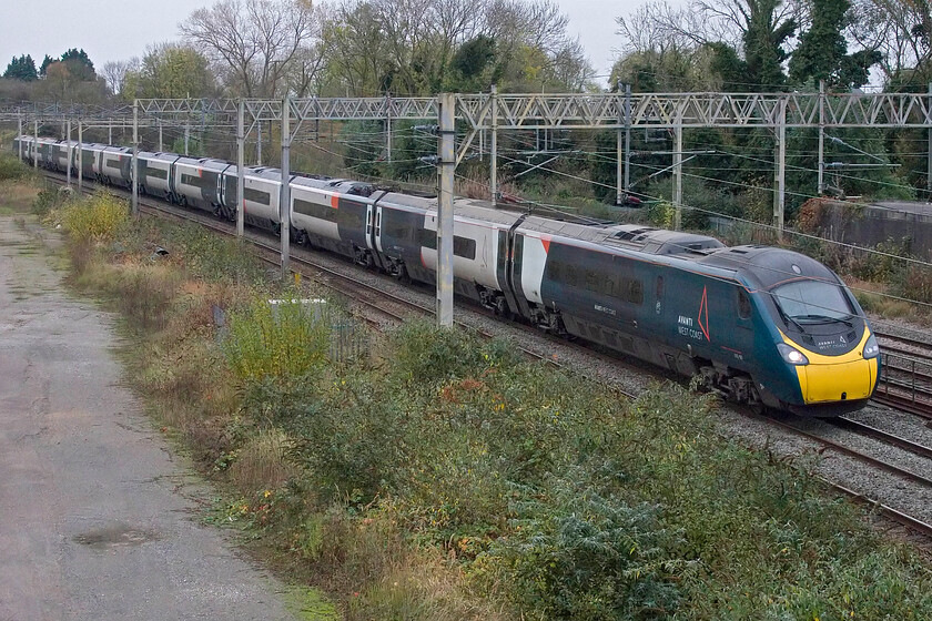 390107, VT 08.10 London Euston-Liverpool Lime Street (1F13, 32L), site of Roade station 
 Yet another grey and miserable morning finds 390107 working the 08.10 Euston to Liverpool service past Roade but on the down slow line. This means that it will take the less direct rout between here and Rugby via Northampton. 
 Keywords: 390107 08.10 London Euston-Liverpool Lime Street 1F13 site of Roade station AWC Avanti West Coast Pendolino