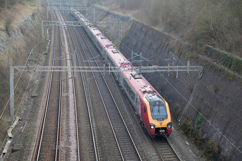 Class 221s, VT 13.43 London Euston-Glasgow Central (9S77), Roade Cutting 
 A pair of conjoined Class 221 Voyagers form the 13.43 Euston to Glasgow central through Roade Cutting. If I thought that the running of diesel power between Euston and Birmingham under electrified wires was a waste, how about this one doing the 400 miles between London and Glasgow; what a waste of energy! 
 Keywords: Class 221 13.43 London Euston-Glasgow Central 9S77 Roade Cutting