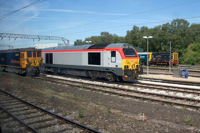 73962, 67025, 09204 & 08752, stabled, Crewe LNWR 
 I am not a fan of photographs taken through train windows but I will always have a go as some interesting scenes can be captured as is the case here. Passing Crewe's LNWR depot located to the eastern side of the mainline to the south of the station often reveals some exotic locomotives. In this view, GBRf's 73962 can be seen to the left with Transport for Wales liveried 67025 in the centre. This is my first photograph of these repainted Class 67s that haul the 'Premiere Service' trains between Holyhead and Cardiff Central. By December these trains will be joined by some rakes of former LNER Mk.IV stock and further Class 67s supplementing services between South Wales and Manchester when the Class 175s are withdrawn to themselves be replaced by new-build CAF Class 197s - complicated isn't it! 
 Keywords: 73962 67025 09204 08752 stabled Crewe LNWR