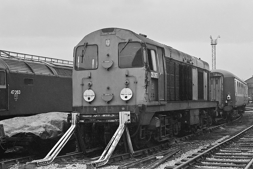 47263 & 20097, Crewe Works 
 With the tablet catcher equipment recess under the number still in place, 20097 is giving away a little about its history. This equipment was only fitted to Scottish machines and indeed, as D8097 it was new to Eastfield in November 1961. In this image, it looks as if it has met with a relatively minor accident judging by the damage to the cab front. Repairs were authorised but took a long time as I saw the same locomotive in the same condition on a subsequent visit some seven months after this picture was taken. The locomotive remained in service until September 1989 eventually returning to Scotland, where it started out its working life, to be cut up at Springburn in 1992. To the left of the Class 20 is 47263 that as D1963 was new to Cardiff Canton in 1965. It was obviously at Crewe for overhaul as I had haulage behind it three months after this picture was taken when it was still in very smart and fresh paint! It survived into the privatisation era becoming 47736 as a RES (Rail Express Systems) machine ending its days at Ron Hull's scrapyard in Rotherham towards the end of 2007. 
 Keywords: 47263 20097 Crewe Works