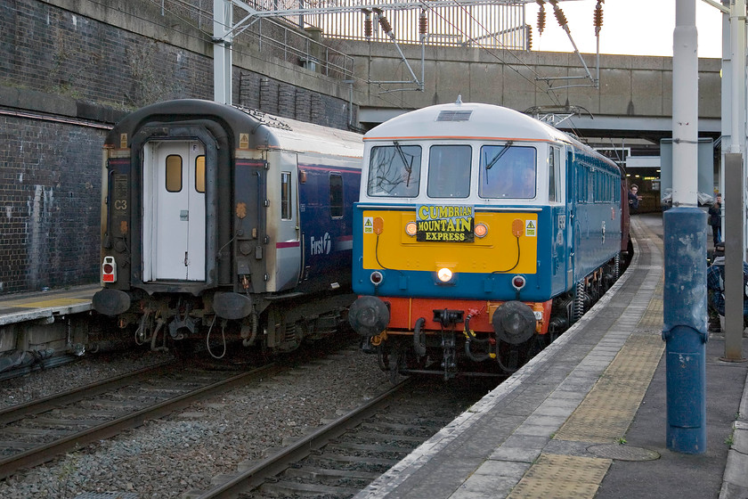 86259, outward leg of The Winter Cumbrian Mountain Express, 07.09 London Euston-Carlisle (1Z86), London Euston station 
 Just a couple of minutes late (according to the camera's time code) The Winter Cumbrian Mountain Express charter gets away from Euston lead by 86259 'Les Ross/ Peter Pan'. According to records taken on the day, the train ran to time throughout the outward and return legs. Notice the enthusiasts indulging in some window leaning from the front coach taking in the joys of some vintage AC electric haulage! 
 Keywords: 86259 The Winter Cumbrian Mountain Express 07.09 London Euston-Carlisle 1Z86 London Euston station Railway Touring Company RTC Les Ross Peter Pan