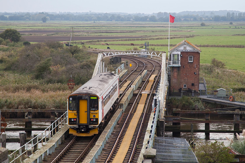 153309, LE 12.58 Norwich-Lowestoft (2J76), Reedham swing bridge 
 153309 rattles across Reedham's swing-bridge working the 12.58 Norwich to Lowestoft. Notice the interesting approved walkway for the signalman to access the box. After accessing the line through a gate just at the side of the metal cage in the foreground, the signaller walks along the yellow/brown pathway set into the down line between the tracks. On reaching the box, the path turns right so that the steps can be accessed at the far end. 
 Keywords: 153309 12.58 Norwich-Lowestoft 2J76 Reedham swing bridge