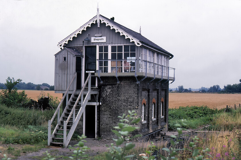 Shepreth signal box (GN, 1878) 
 Another classic Great Northern box this time dating from 1878 at Shepreth. The photograph is taken from the down platform end of the station. Notice that the box is set back giving the signalman a better view of both the up and down lines that were sharply curving through the station at this point. The box was to close in February 1983 with control of this route passing to Cambridge's new PSB. Also notice the signalman in the box topless and appearing to be shaving between trains! I also love the super toilet block perched on the veranda reminding me somewhat of Grandpa's (played by Lionel Jeffries) hut that was carried away by the airship in the 1968 film Chity Chity Bang Bang! 
 Keywords: Shepreth signal box GN Great Northern