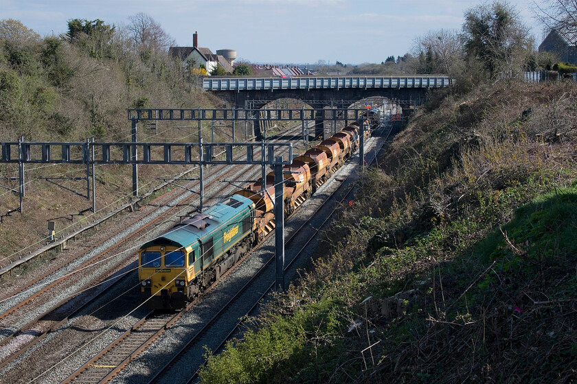 66565, ballast train, Hyde Road bridge 
 66565 continues to reverse at a walking pace along the down fast line at Roade seen from Hyde Road bridge. It is easing a short set of HQA(E) eight-tonne autoballasters back towards a work site where ballast was required. 
 Keywords: 66565 ballast train Hyde Road bridge