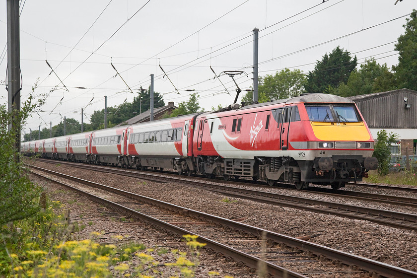 91128, GR 09.00 London Kings Cross-Edinburgh (1S09, 9L), Tempsford Crossing 
 The 1S09 09.00 King's Cross to Edinburgh races past Tempsford level crossing with 91128 'InterCity 50' leading. The roof of the old Tempsford goods shed can be seen above the second Mk. IV coach. It is in use today as is the old station building. Tempsford station closed on 05.11.56. 
 Keywords: 91128 1S09 Tempsford Crossing