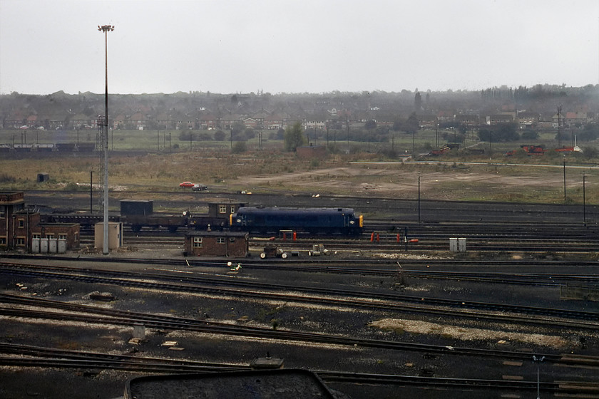 44007, down freight, Toton Yard 
 Whilst I was up on the bank, at the southern end by the old wagon works sidings, 44007 (ex D7 'Ingleborough') rolled into the yard from the south with a short mixed freight of what looked to be vacuum-braked engineering wagons. I was a little miffed that I was high up on the bank and so far from the train so thought that I would make do with this side on and very distant photograph. However, it does show the land behind the train that was once covered with yet more sidings, today the same view is very different, see..... https://www.ontheupfast.com/p/21936chg/29595735604/x17-60008-60075-60004-stored-toton 
 Keywords: 44007 freight Toton Yard