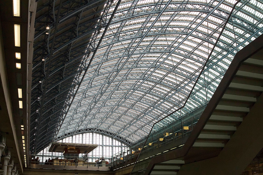 Interior, London St 
 Never ever did I think that when I visited a dirty and very run-down St. Pancras in the 1970s and 1980s that it would be re-born and morph into what it has become today! The magnificent and restored William Henry Barlow designed train shed dominates this view looking up from the undercroft that now contains a huge range of retail outlets. On the platform level in this image the famous champaign bar can be seen, a favourite haunt for the more affluent traveller prior to their departure be it either on East Midlands, Southeastern or Eurostar services. 
 Keywords: London St. Pancras station