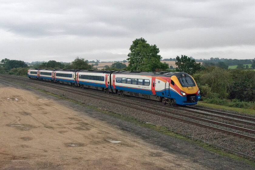 222023, EM 07.02 London St. Pancras-Sheffield (1F10, RT), Braybrooke SP769849 
 In appalling light that has needed a fair bit of Photoshop 'treatment' to get it presentable EMR's 222023 works the 07.02 St. Pancras to Sheffield service. It is passing Braybrooke, a small village right on the Northamptonshire and Leicestershire county boundary. The photograph is taken from a huge and somewhat over-engineered steel bridge that carries a bridleway across the line that I think sees a limited number of horse riders passing over it. The large area of flat and cleared land in the foreground is where a large and important power supply building will be constructed as part of the electrification programme. 
 Keywords: 222023 07.02 London St. Pancras-Sheffield 1F10 Braybrooke SP769849 EMR Intercity Meridian