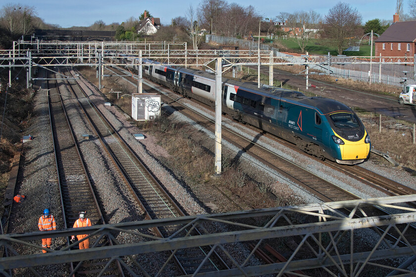 390130, VT 07.37 Edinburgh Waverley-London Euston (1M08, 3L), site of Roade station 
 As two track workers involved in extensive embankment clearances walk along the up fast line at Roade 390130 'City of Edinburgh' heads south on the up slow line working the 1M08 07.37 Edinburgh to Euston service. For a week now all Avanti West Coast and other services for that matter were being diverted through Northampton avoiding the Weedon route due to Network Rail taking the opportunity to undertake much maintenance work taking advantage of the significant reduction in services due to COVID. 
 Keywords: 390130 07.37 Edinburgh Waverley-London Euston 1M08 site of Roade station City of Edinburgh