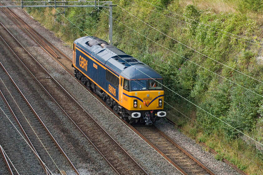 69008, 16.18 Northampton EMD-Kettering Stabling Sidings (0F62, 1E), Hyde Road bridge 
 The first of two Class 69s to pass through Roade cutting within thirty minutes of each other. 69008 'Richard Howe' runs light engine as the 16.18 Northampton EMD to Kettering Stabling Sidings that will then continue north returning to Leicester LIP depot. Earlier in the day, the 69 had brought a Class 360 from Kettering to Northampton for servicing and an exam. Usually, it would take one back but not today. When this has happened in the past the light engine Class 69 has often returned to Leicester via a dash along the WCML to Nuneaton where it would then reverse and complete its journey through Hinkley and Narborough. 
 Keywords: 69008 16.18 Northampton EMD-Kettering Stabling Sidings 0F62 Hyde Road bridge gbrf Richard Howe