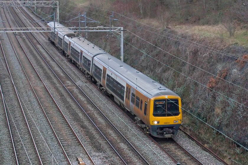 323212, 11.48 Soho LMD-Wolverton Centre Sidings (5J70, 2E), Hyde Road bridge 
 West Midlands Trains is preparing to dispose of its Class 323 fleet due to the arrival of the Class 730s - whenever that may happen! Some of the fleet are heading north to Northern to augment their operations with the withdrawal of the Class 319s underway. For this to happen work is being undertaken by Wolverton Works meaning that units head south of their usual area of operation. Here, 323212 formally named 'Bromsgrove' passes through Roade as the 5J70 11.48 Soho Depot to Wolverton Centre Sidings 
 Keywords: 323212 11.48 Soho LMD-Wolverton Centre Sidings 5J70 Hyde Road bridge ECS West Midlands Railway