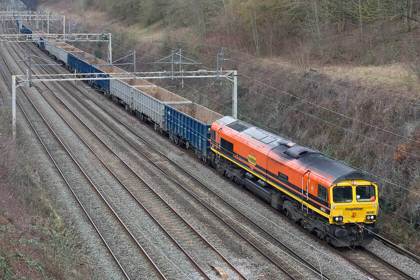 66502, 10.59 New Bilton-Willesden Eurotermnal (4R98, 2E), Hyde Road bridge 
 The second rake of empty JNA wagons heads south through Roade within five minutes or so. Unlike the previous train that had some heritage haulage, this one is a little more conventional with 66502 'Basford Hall Centenary 2001' leading. The train, also in association with HS2 work, is the 10.59 New Bilton (Rugby) to Willesden Euroterminal empties. 
 Keywords: 66502 10.59 New Bilton-Willesden Eurotermnal 4R98 Hyde Road bridge Basford Hall Centenary 2001