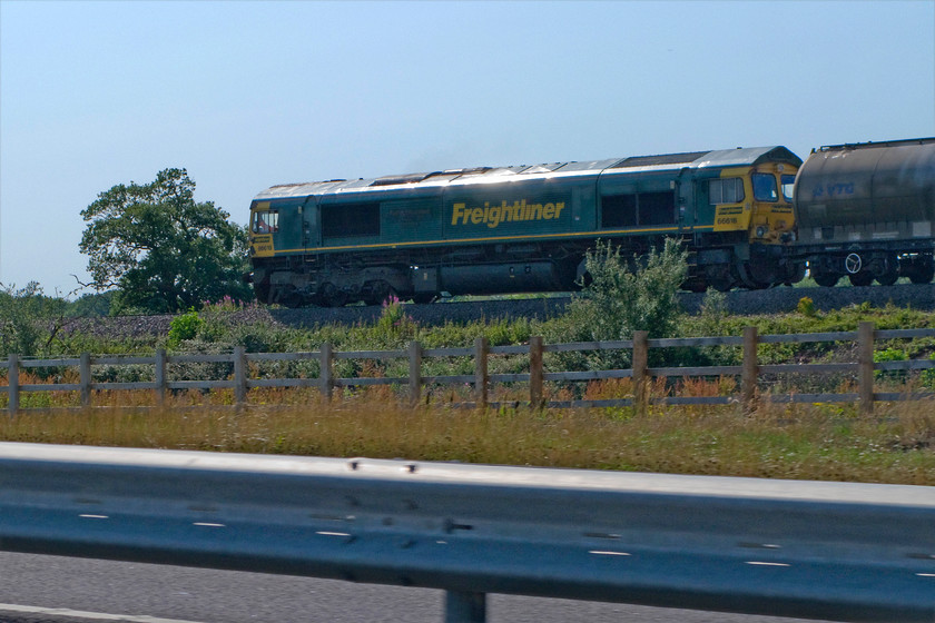 66618, 11.49 Tunstead Sidings-West Thurrock Sidings (6L87), from Golf YB03JNK, A43 Corby southern ring road 
 The recently opened Corby southern ring road is now designated as part of the A43 that opened last year in 2014 runs parallel to the railway for some two miles. 66618 is seen leading the 6L87 11.49 Tunstead to Thurrock cement train along the recently redoubled track south-west of Corby. 
 Keywords: 66618 11.49 Tunstead Sidings-West Thurrock Sidings 6L87 A43 Corby southern ring road