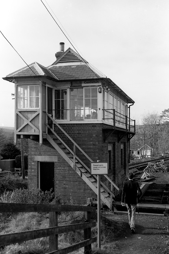 Castleton Signal Box (NER, date not known) 
 The signalman walks back to Castleton signal box having taken possession of the token from the driver of the DMU on which I am travelling. Unlike the much simpler design of NER box at Glaisdale, this one has the unusual gable mounted ventilators mounted within the gablet (Dutch gable). Off course, the box has now closed and has been demolished and the goods siding in the background has been lifted. 
 Keywords: Castleton Signal Box NER North Eastern Railway