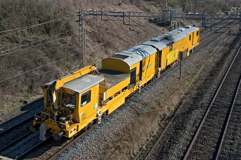 DR80201, 11.05 Wembley Yard-Rugby Carriage Sidings (RT), Victoria bridge 
 Having been involved in trackbed maintenance overnight in the north London area Stoneblower DR80201 heads back to its base at Rugby. Running as the 11.05 Wembley Yard to Rugby CS it is seen in some pleasant sunshine passing Victoria bridge between Roade and Ashton. Performing very similar functions to the tampers these YZA units maintain the profile of the ballast rather than having the tines that insert themselves into it to profile the track itself. 
 Keywords: DR80201 11.05 Wembley Yard-Rugby Carriage Sidings Victoria bridge