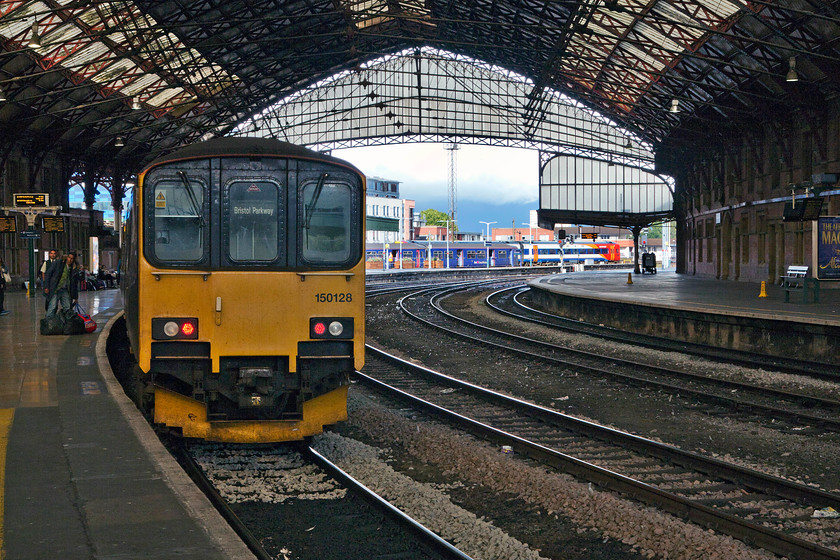 150128, GW 14.07 Taunton-Bristol Parkway (2U20), Bristol Temple Meads station 
 On a day of extremely changeable weather it looks like another storm is brewing in the distance! 150128 has just arrived working the 14.07 from Taunton to Bristol Parkway. It stands inside the grand train shed that was opened in the 1870s following the need for expansion and through trains. It was funded jointly between the Great Western, the Bristol and Exeter and the Midland Railways who also had operating rights. 
 Keywords: 150128 14.07 Taunton-Bristol Parkway 2U20 Bristol Temple Meads station