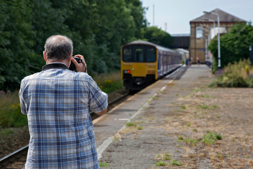 Andy & 150137, NT 13.22 Manchester Victoria-Blackpool North, Kirkham & Wesham station 
 Andy focuses his camera on the rear of 150137 as waits at Kirkham and Wesham station working the 13.22 Manchester Victoria to Blackpool North service. This station used to have large canopies being built in the same style as Poulton-le-Fylde which we visited a little earlier in the day. The two stations could now not be more different with Kirkham feeling very unloved and run down when compared to Poulton just a few miles further west. 
 Keywords: Andy 150137 13.22 Manchester Victoria-Blackpool North Kirkham & Wesham station Northern