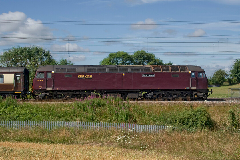 57314, 09.02 London Euston-Milton Keynes Central (1Z60, 4L), between Roade & Ashton 
 57314 'Conway Castle' leads the outward leg of the Grand Prix special that started out from Euston at 09.02 running as 1Z60. Passengers would disembark at Milton Keynes but as the journey from London to there was not long enough to enable a relaxing breakfast experience the train continued to Northampton to then return south to Milton Keynes thus adding an hour to its journey time! The train is seen passing the fields between Roade and Ashton with the barley in the foreground ripening nicely! 
 Keywords: 57314 09.02 London Euston-Milton Keynes Central 1Z60 between Roade & Ashton Conway Castle