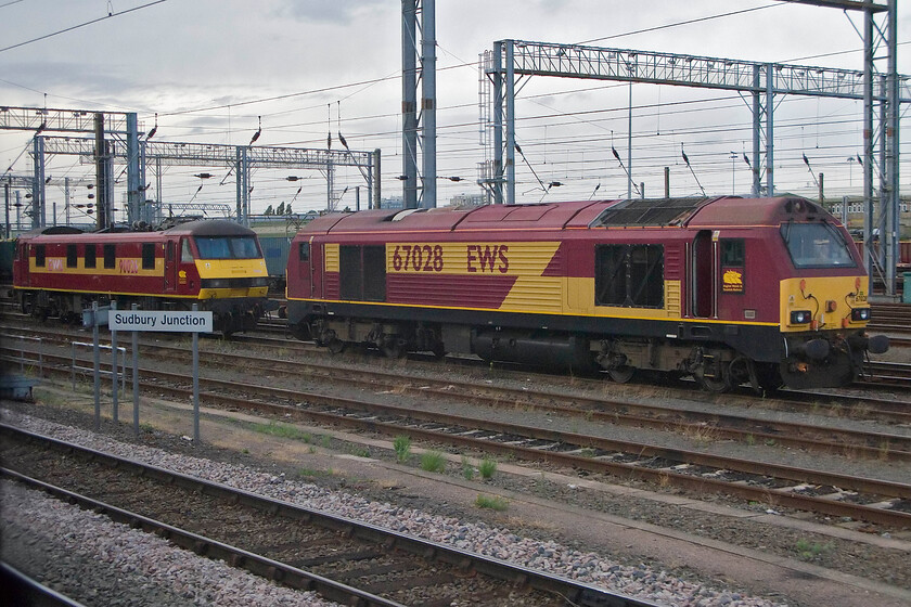 90026 & 67028, stabled, Wembley Yard 
 Like the last image, the German operator Deutsche Bahn appears to be making very little progress in the re-branding of their assets with their EWS branding and livery still much in evidence. No more so than in Wembley Yard with 90026 and 67028 stabled awaiting their next job probably at the start of the working week tomorrow. 
 Keywords: 90026 67028 Wembley Yard EWS