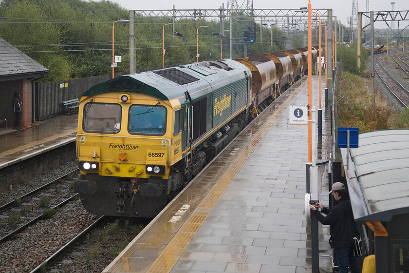 66597, 09.44 Bescot Yard-Bromford Bridge (6Y61, 43L), Bescot Stadium station 
 The second engineering train within ten minutes taking the same route passes Bescot Stadium station. As the first one was late departing from the Up Yard due to the lateness of the inbound locomotives, this one is also behind schedule but not by so much time. 66597 'Viridor' leads the 09.44 Bescot Yard to Bromford Bridge 6Y61, a circular journey of just over seventeen miles. 
 Keywords: 66597 09.44 Bescot Yard-Bromford Bridge 6Y61 Bescot Stadium station Freightliner Viridor