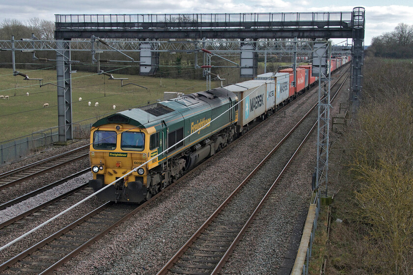 66562, 07.50 Felixstowe North-Lawley Street (4M94, 18E), Cathiron SP4667783 
 Not the finest of photographs when it comes to composition with the catenary getting in the way but it was a rushed shot. As I was climbing the steps of the bridge at Cathiron I saw the 07.50 Felixstowe to Lawley Street Freightliner approaching with 66562 leading. I rushed to the opposite side of the bridge and lay down to avoid the signalling gantry blocking the view and secured this what must only be described as a purely record image. 
 Keywords: 66562 07.50 Felixstowe North-Lawley Street 4M94 Cathiron SP4667783 Freightliner