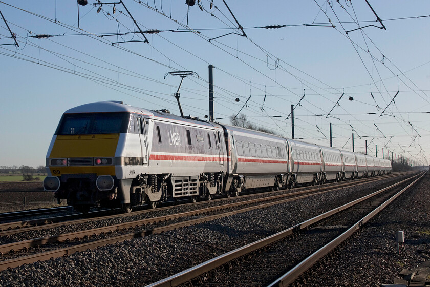 91109, GR 12.02 York-London King's Cross (1Y84, 29L), Holme Green crossing TL192426 
 As the 1Y94 12.02 Yoek to King's Cross LNER service sped south past me at Holme Green crossing Langford led by the DVT I could not resist swiftly turning my camera around to capture the Class 91 pushing at the rear. 91109 'Sir Bobby Robson' looks superb in its retro. InterCity swallow livery matched to the set of Mk. IV stock as it catches the fast-sinking February afternoon sunshine. 
 Keywords: 91109 12.02 York-London King's Cross 1Y84 Holme Green crossing TL192426 IC225 Sir Bobby Robson